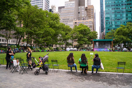New York City - June 12, 2021:  Scene from historic Bryant Park in midtown Manhattan on a Saturday afternoon with people visiting and event stage in the background.のeditorial素材