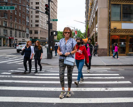 New York City - June 12, 2021: Midtown Manhattan street scene with people crossing the street at crosswalk.のeditorial素材