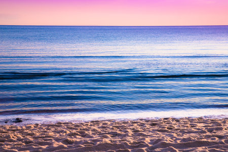 View from beach at sunset with ocean, colorful sky and sea