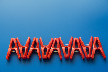 red clothes peg on blue background