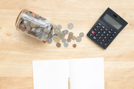 Thai coins with black calculator and pencil on notebook paper, top view with copy spaceの写真素材
