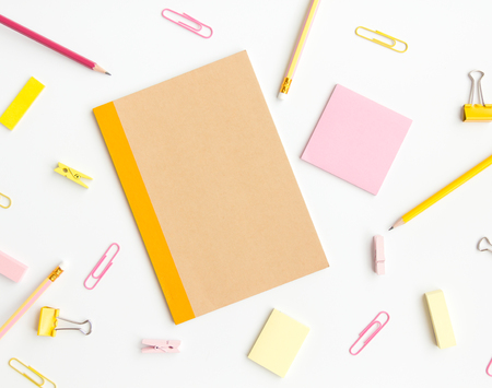notebook paper, sticky note with pencil, paper clip on white backgroundの写真素材