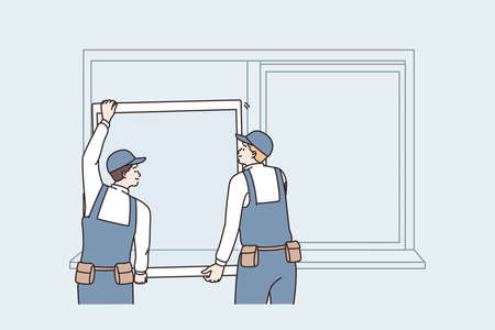 Repairing and reconstruction at home concept. Two men workers in uniform standing changing window...