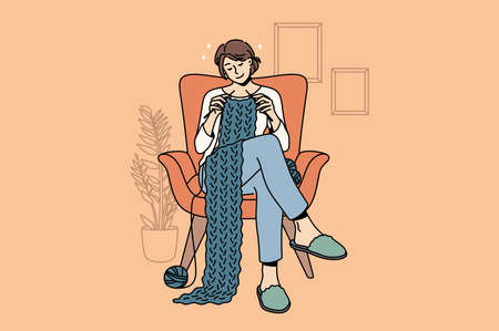 Knitting and Home hobbies concept. Young smiling woman cartoon character sitting at home in armchair knitting scarf with wool enjoying hobby vector illustrationのイラスト素材