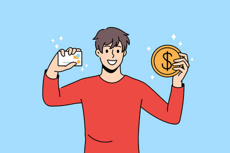 Smiling young man hold credit card and bitcoin excited about good investment. Happy guy trader...