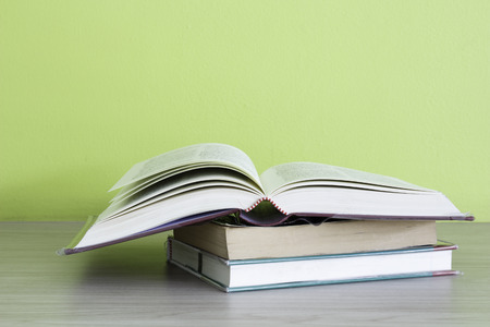 books on wooden deck table and green backgroundの写真素材
