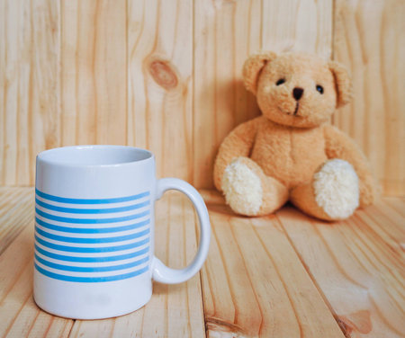 A coffee cup with teddy bear and wooden background. vintage style.の写真素材