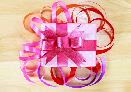 Gift box and colorful of ribbon on wood background.の写真素材