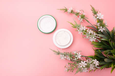 hand cream on a pink background with flowers. concept of beauty and skin care.の写真素材