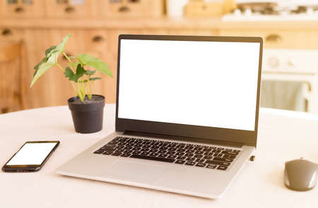 A workplace in a bright kitchen during quarantine. Laptop with place for text. Telework. freelance....