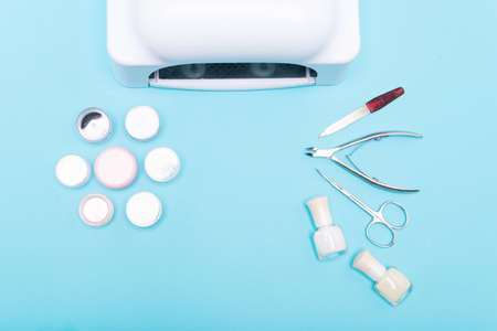 Beauty accessories for manicure and pedicure on a light blue background. Samples of nail polish, scissors and other accessories for home and salon procedures. Copy space.の写真素材