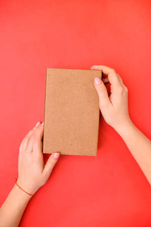 Hands with a gift on a red background, top view. Place for text. Scenery: matathan and starsの写真素材