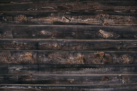 Vintage brown wood background texture with knots. Old painted wood wall. Brown abstract background. Vintage wooden dark horizontal boards. Yop view with copy space. Background for deskの写真素材