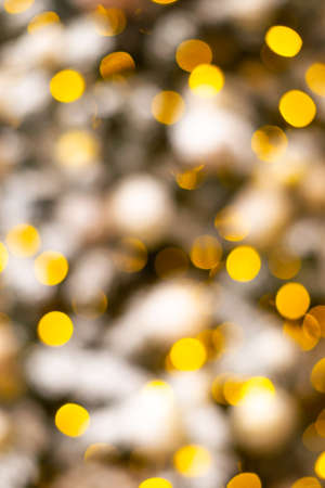 Colorful yellow Christmas Tree Bokeh background of de focused glittering lights. Pattern concept. Festive xmas bokeh defocused lights, close upの写真素材
