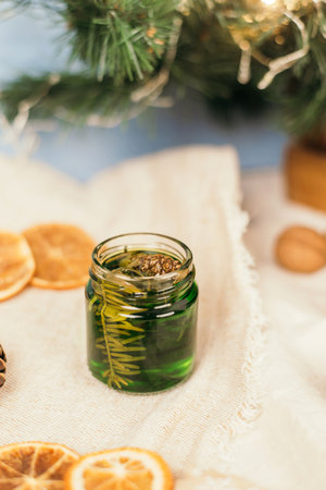 Green honey with pine needles in a glass jar. Glass jar with honey on a christmas atmosphere background. National Recipes. jamの写真素材