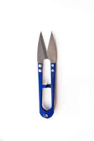 Blue scissors to cut the thread isolated on white background
