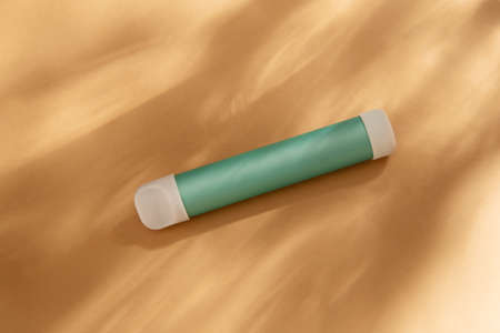 mint stick - disposable vaping device, electronic cigarette on a beige background. Flat lay, top view, minimal design with shadows of sunlightの写真素材