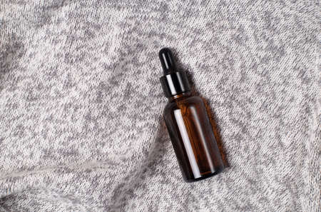 brown dropper glass bottles with pipette on gray fabric background. Zero waste glass containers. Serum, oil, acid, lotion. Organic, natural cosmetic. Beauty, skincare. Spa products.の写真素材