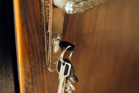 Unlocking a house door with a key on a keyring close up. old doorの写真素材