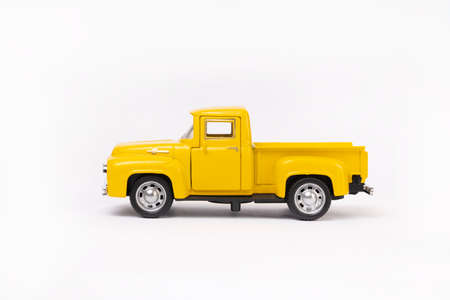 miniature toy car of yellow color isolated on white background. retro pickup truck.の写真素材