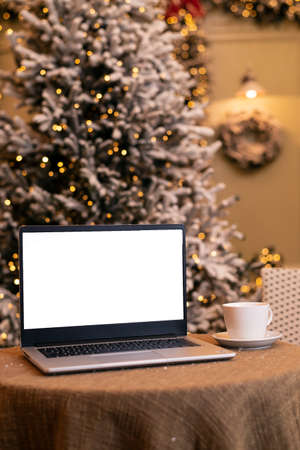 laptop in a winter atmospheric coffee shop, against the background of a Christmas tree. Remote work. workplace. season of discounts and shopping.の写真素材