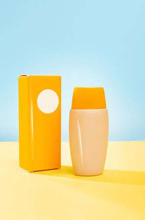 Mockup of a bottle for cosmetic product, with a label for design, a orange cardboard box. Cosmetics...