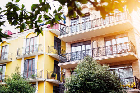 The facade of house with beautiful balcony in summer sun rays. Balcony with metal railings. Laconic minimalist concept.の写真素材