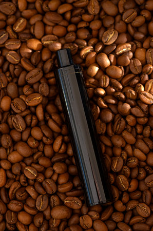 Coffee beans background and E-cigarette. Coffee flavored vape juice conceptの写真素材