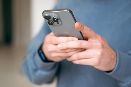 Kyiv, Ukraine. January 9, 2024. Man using a new mobile phone, iphone 15 smartphone close-up.のeditorial素材