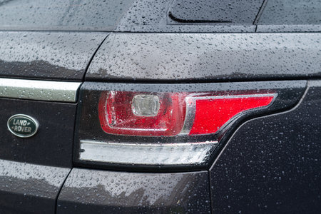 Kyiv, Ukraine - April, 2024: Land Rover Discovery Sport modern gray car with water drops. Body, Taillight close-up.のeditorial素材