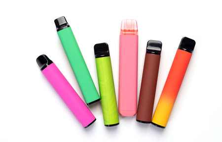 A set of colorful disposable electronic cigarettes of different shapes on a white background. modern...