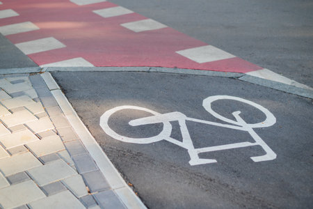 Bike path with bicycle symbol. Red bike lane with non-slip acrylic coating on city footbridge.