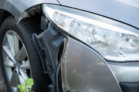 The front of the car damaged in an accident. damaged headlamp after collision close-upの写真素材