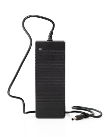 Black power adapter with cable and connector, isolated on white background. Essential accessory for charging devicesの写真素材