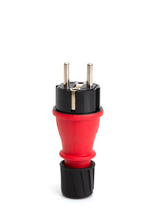 Red and black industrial electrical plug, isolated on white background, used for power connections in heavy-duty and outdoor applications.の写真素材