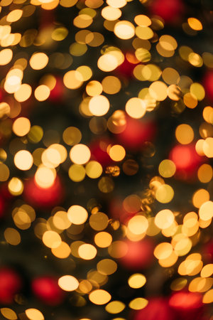 Defocused golden and red bokeh lights create a warm and festive abstract background perfect for holiday themes.の写真素材