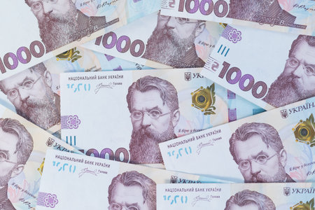 Top view of scattered 1000 Ukrainian hryvnia banknotes featuring Volodymyr Vernadsky.
