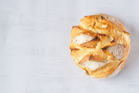 Round Bread Loaf or Boule isolated on the right side. Grey background. Copy space. Top view....