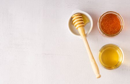 Honey pot with transparent cup of tea and spoon for honey on the table. Grey background. Top view. Isolated. Copy space. Healthy living, immunity. の写真素材
