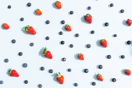Fruit pattern of blueberries and strawberries. Blue background flatlayの写真素材