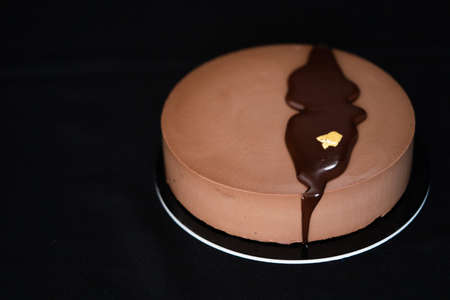 Chocolate glossy birthday cake isolated on a black background. Copy space. Close up. High quality photoの写真素材