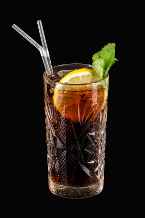 Cuba Libre with brown rum, cola, mint and lemon isolated on black.の写真素材