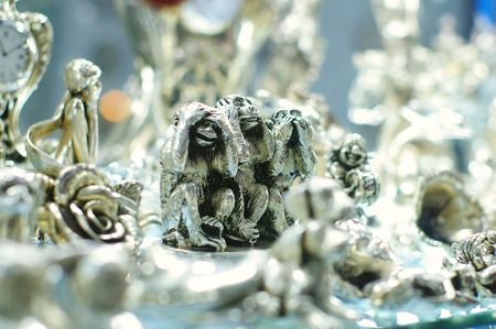 Silver statuettes of funny monkeys with blurred backgroundの写真素材