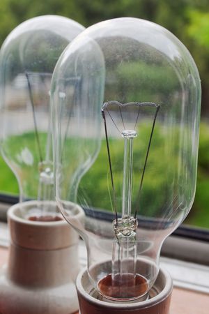 Closeup of two tungsten light bulbs with selective focus  