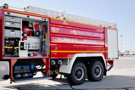 Airport fire truck with opened section with internal mechanisms and devices on tarmacの写真素材