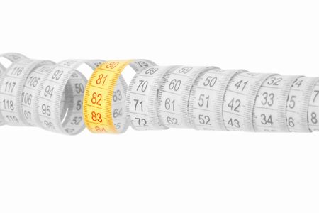 Black and white desaturated rolled measuring tape with colored section in focus from 80 to 84 isolated on whiteの写真素材