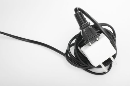 Closeup of American type electric power plug inside European voltage adapter with selective focus isolated on whiteの写真素材