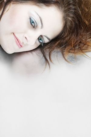 Closeup of a woman's face with blue eyes against grey background with copy spaceの写真素材