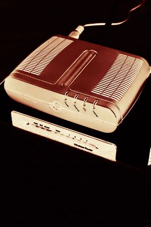 Stylized red ADSL modem on wireless router against black background with selective focusの写真素材