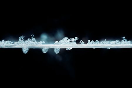 Cyan thread with frozen water drops against black background 